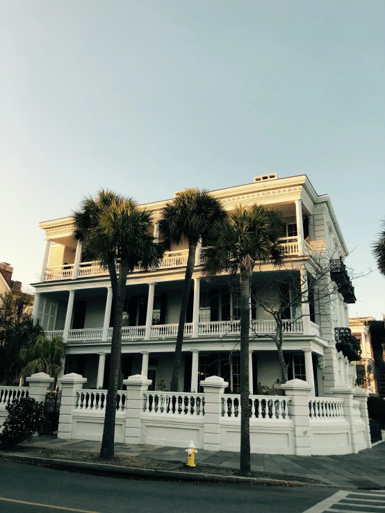 an apartment building is shown with palm trees on the street