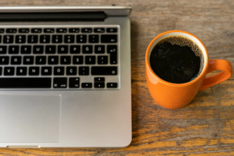 a cup of coffee sitting in front of an open laptop