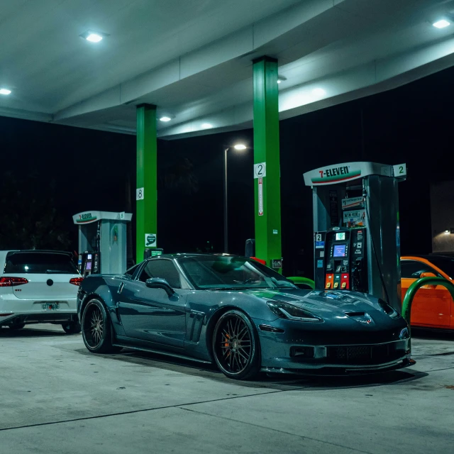 two cars sit at an automatic payment terminal