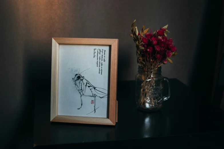 a picture frame sitting next to a vase filled with flowers