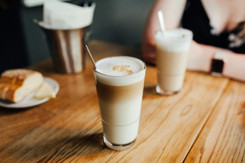 two drinks sitting on top of a table next to donuts