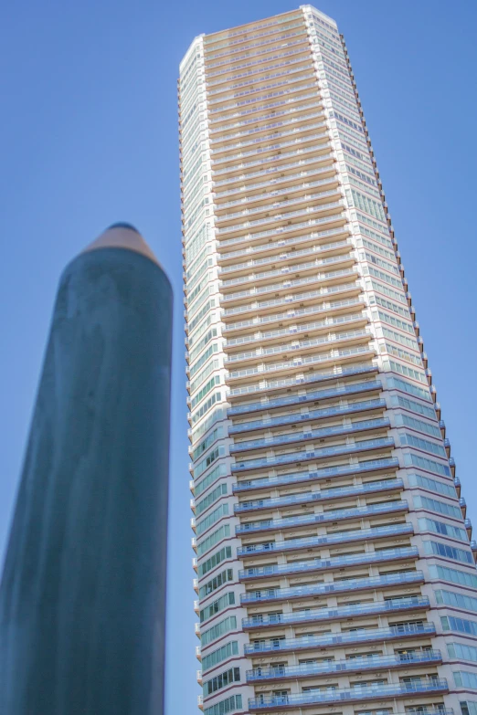 a tall skyscr towering into the sky next to a large blue object