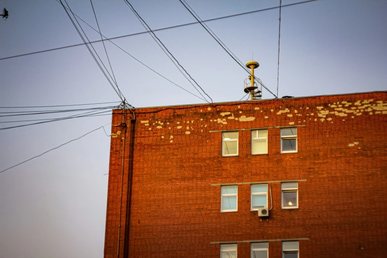 an old red brick building has several power lines above it