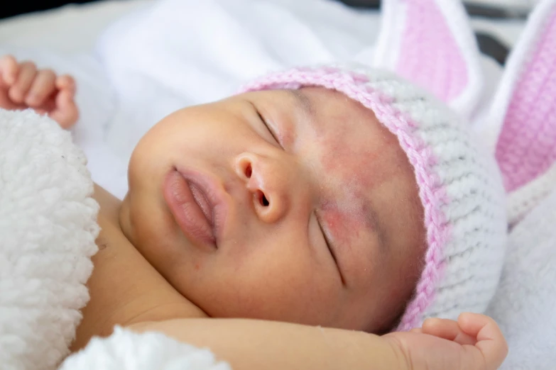 a small baby is wearing a pink hat