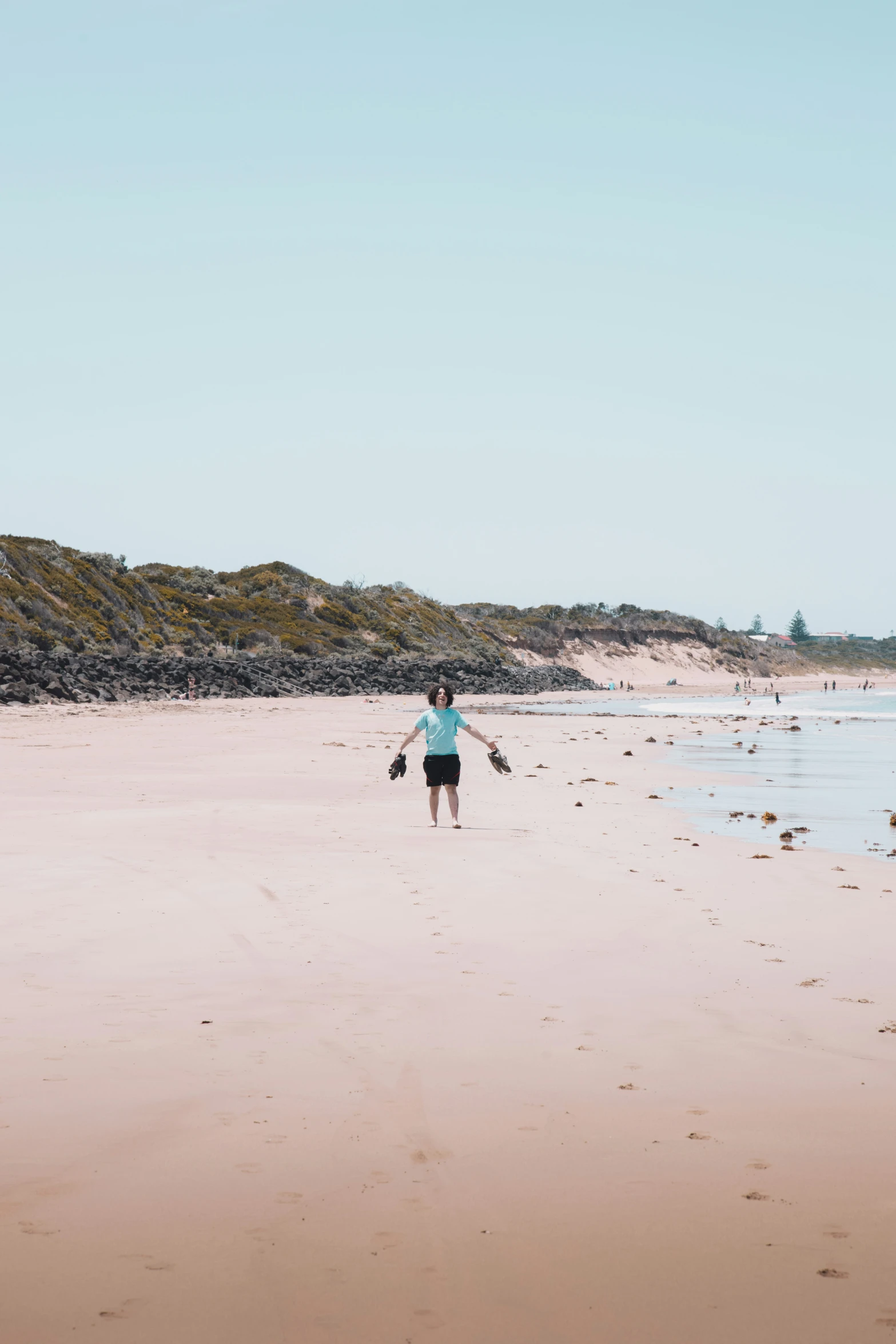 the lady is walking with a dog on the beach