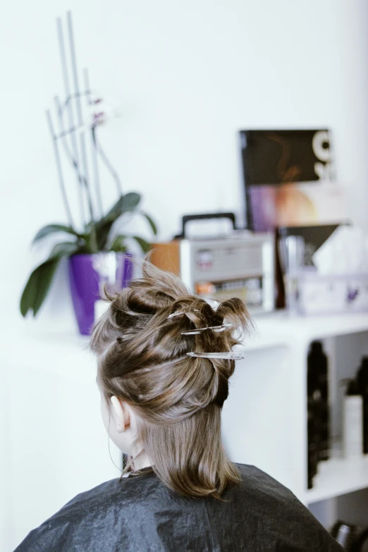 a woman sits in a chair with her hair wrapped up