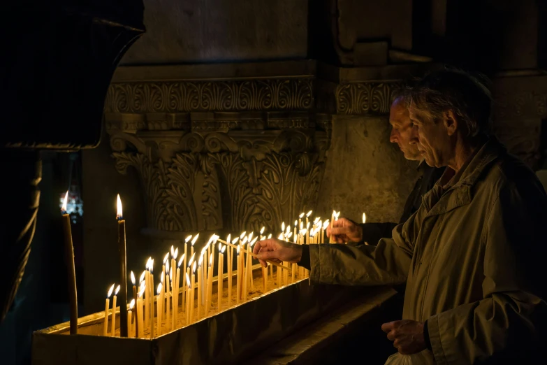 a man lights candles in a church