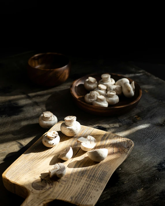 mushrooms sitting on top of a  board next to a bowl of food