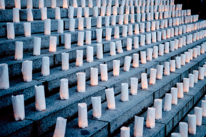 lit candles sitting in a row on some cement