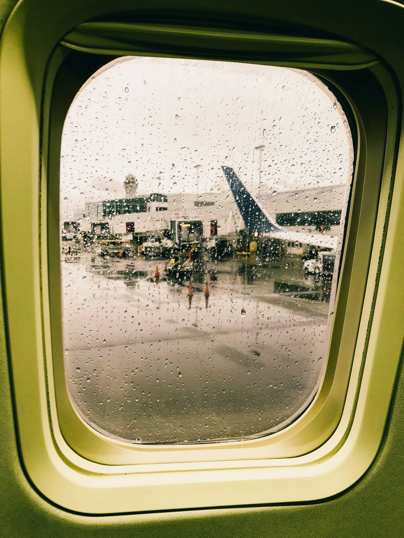 looking out the window of an airplane at a busy airport