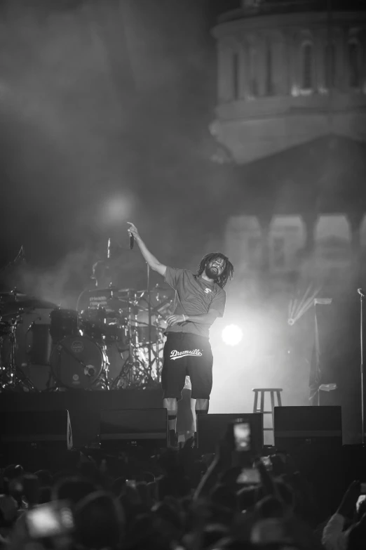 an african american man on stage and with his arms raised