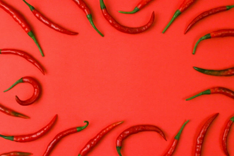 a red background with green peppers and smaller ones in the middle