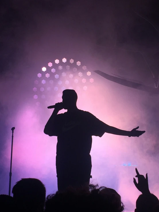 a person on stage with their arms raised