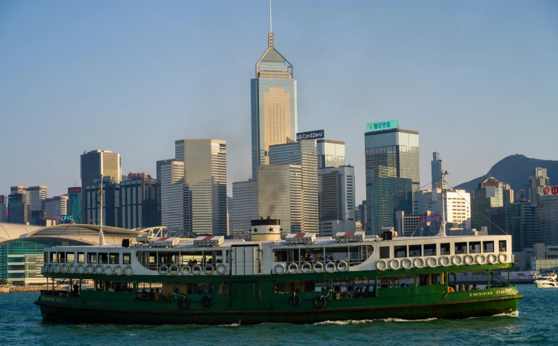 a big boat sailing down a lake in front of tall buildings