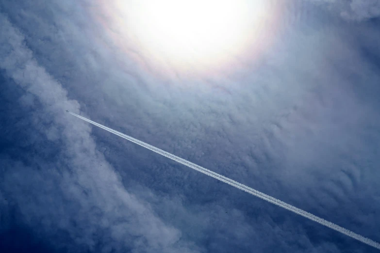 a white airplane flying in the sky near clouds