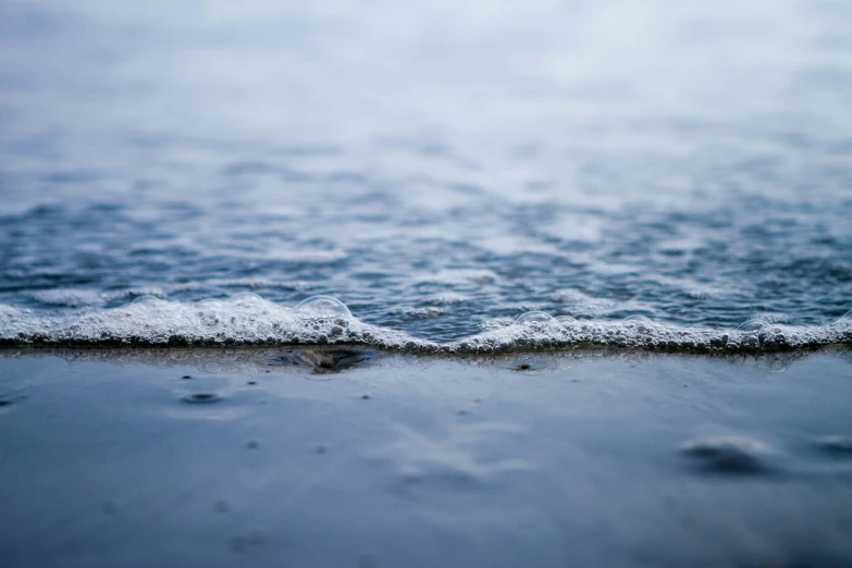 the water on the beach looks like it is frozen