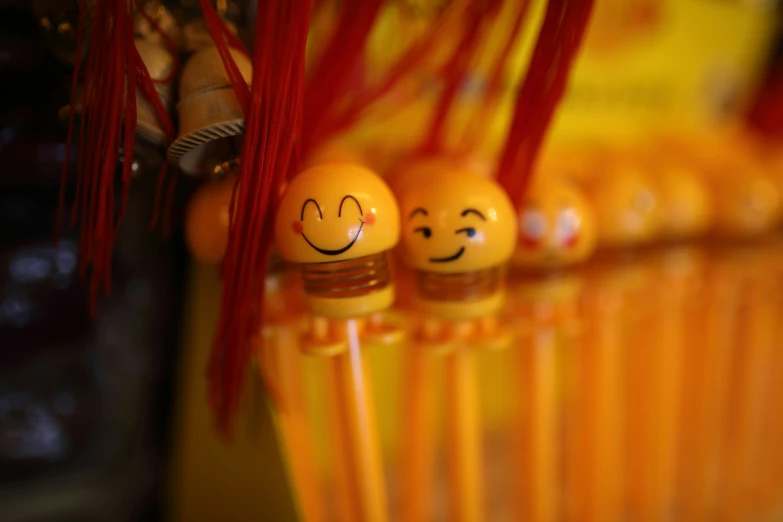 three yellow toothbrushes with smiley faces are lined up in front of the camera