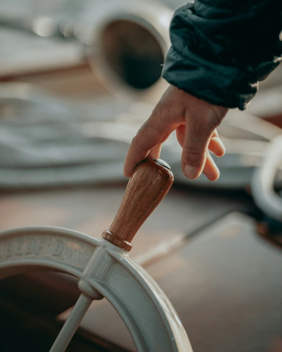 someone is reaching for the steering wheel of a boat