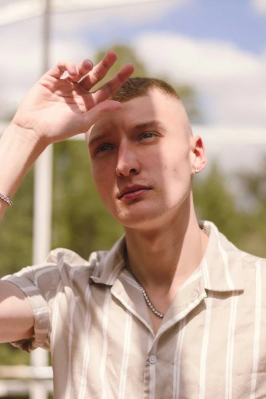 a man with a collared shirt poses in front of an umbrella