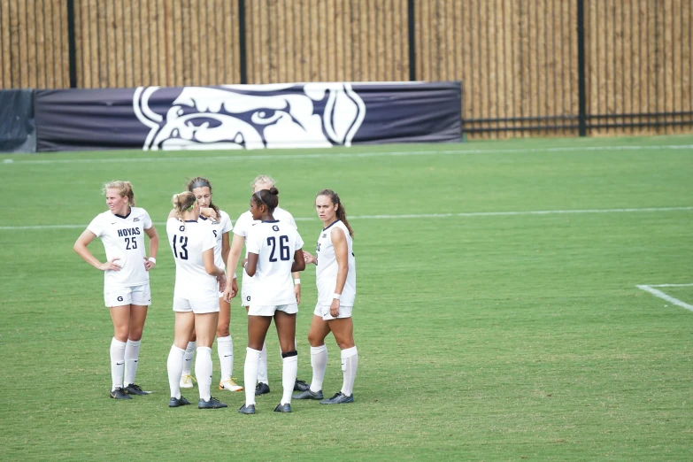 a group of female soccer players standing in a field