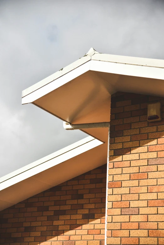 the roof of a red brick building against a grey sky