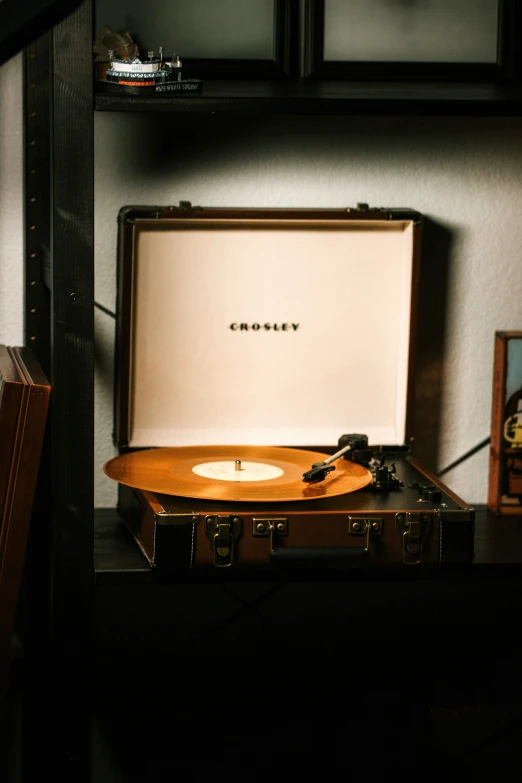 the vinyl player is next to a wooden case on a shelf