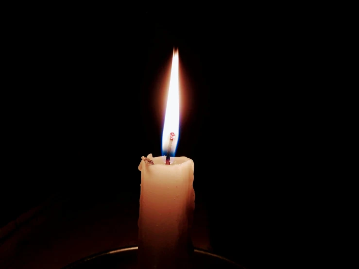 a candle with a black background and some lit up