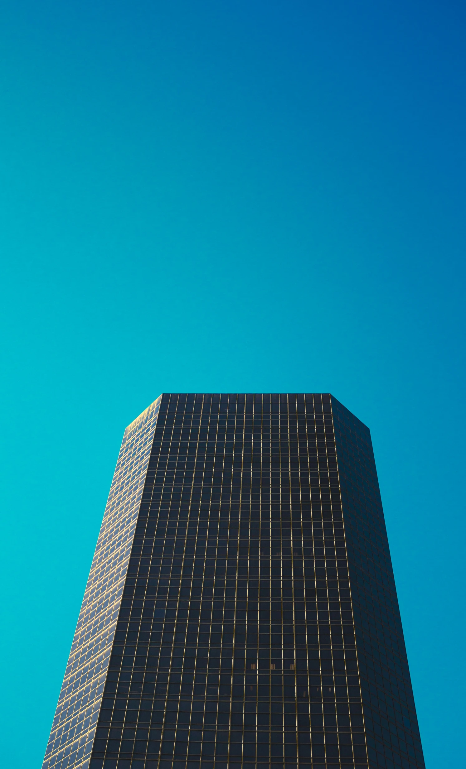 a black building with a plane flying in the background