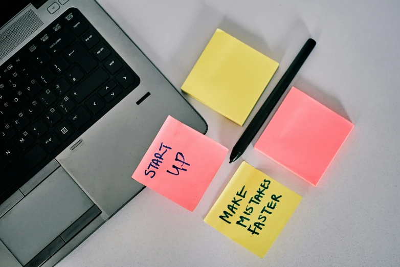 three sticky notes sit on a laptop keyboard