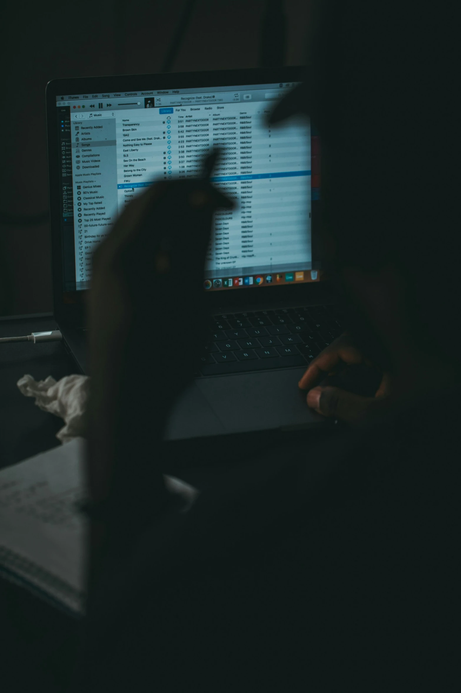 someone using their laptop in the dark with their fingers