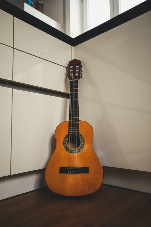 a guitar is laying on the floor in front of a wall