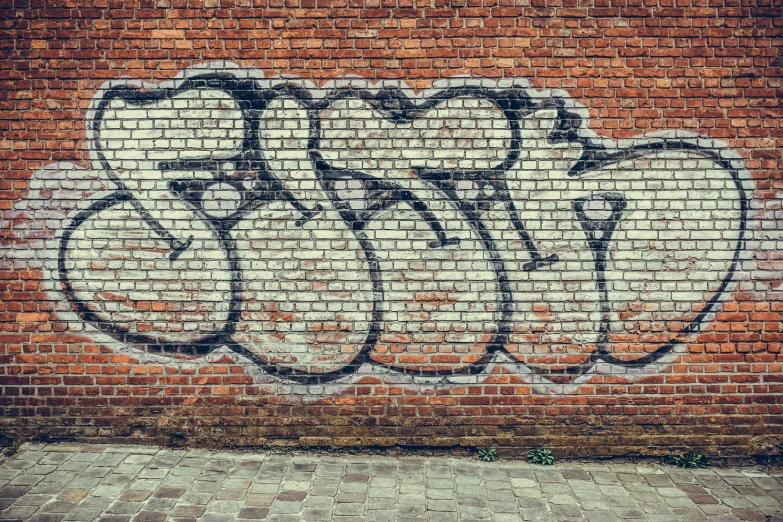 a brick wall with graffiti drawn on it