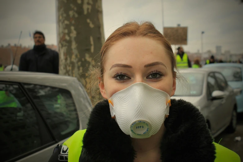 a young woman is standing near a police officer with a mask on