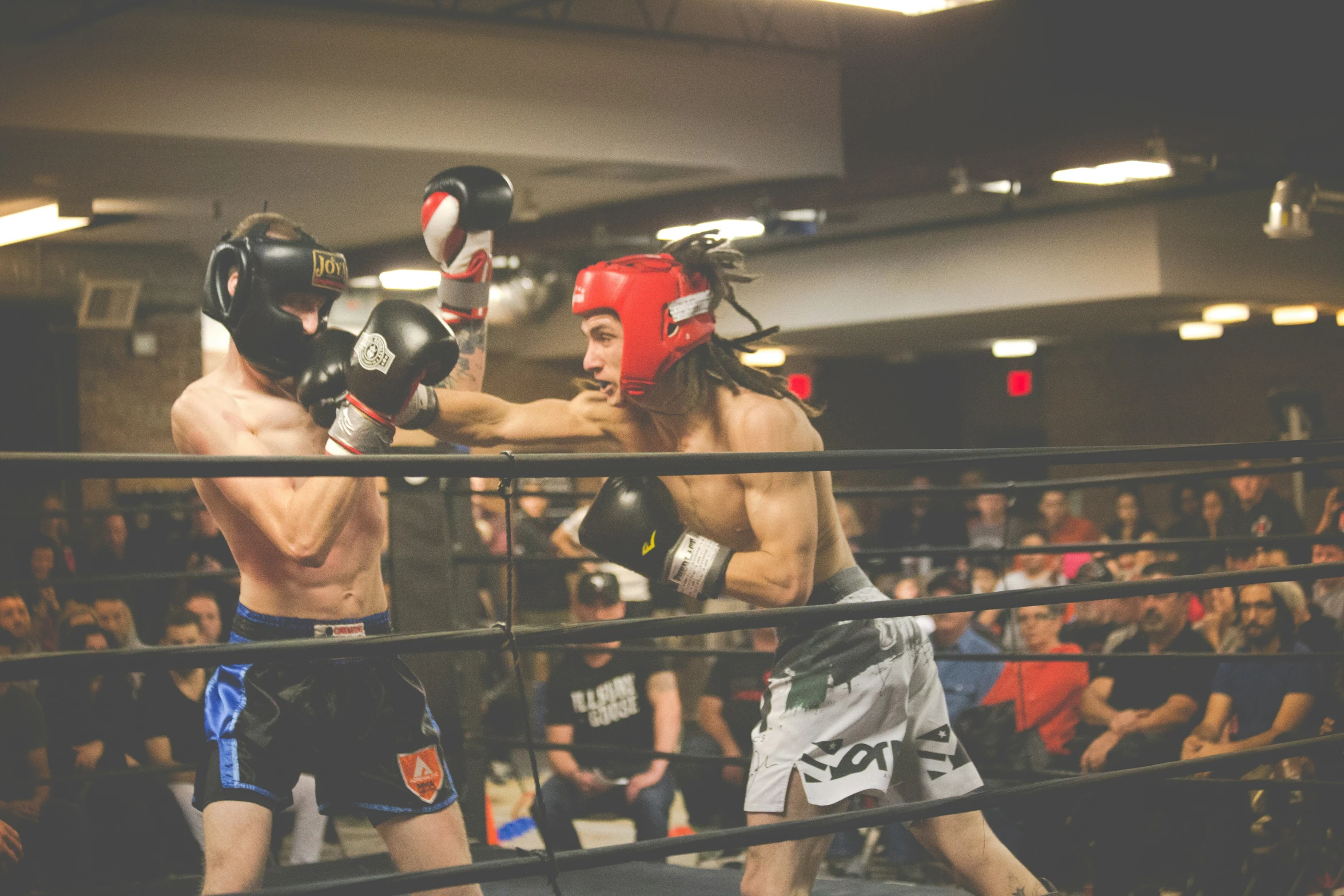 two men wearing boxing trunks in a ring