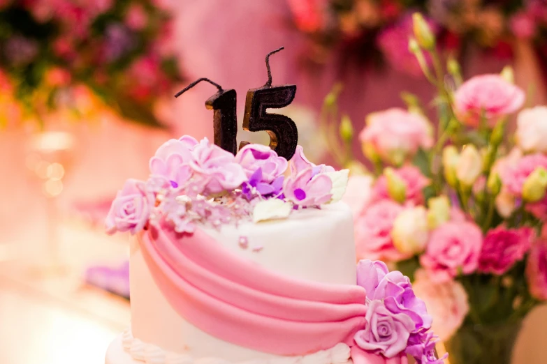 a cake with the number fifteen on it is sitting in a dining room