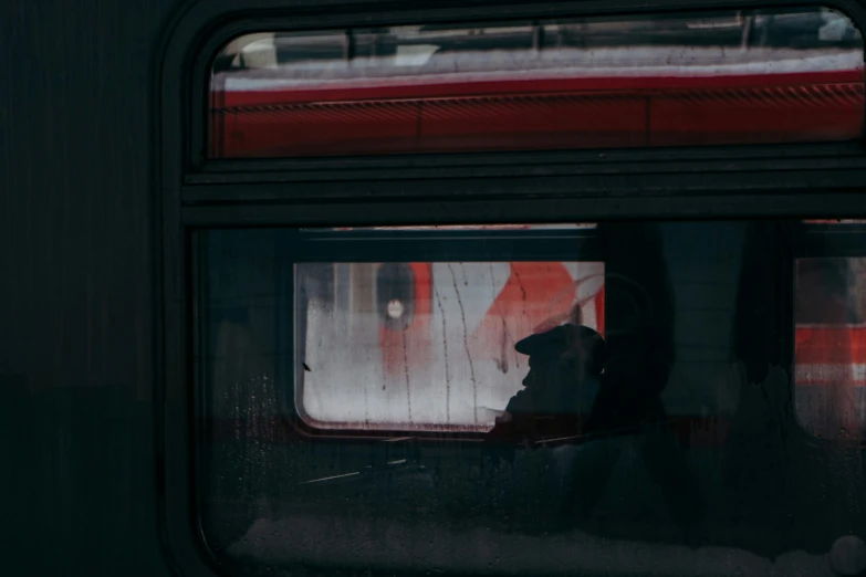 person reflected in a window next to a sign