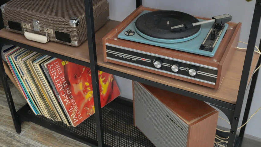 a record player and stereo player are on the shelf