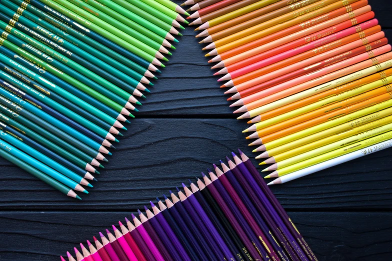 several colored pencils are laying side by side