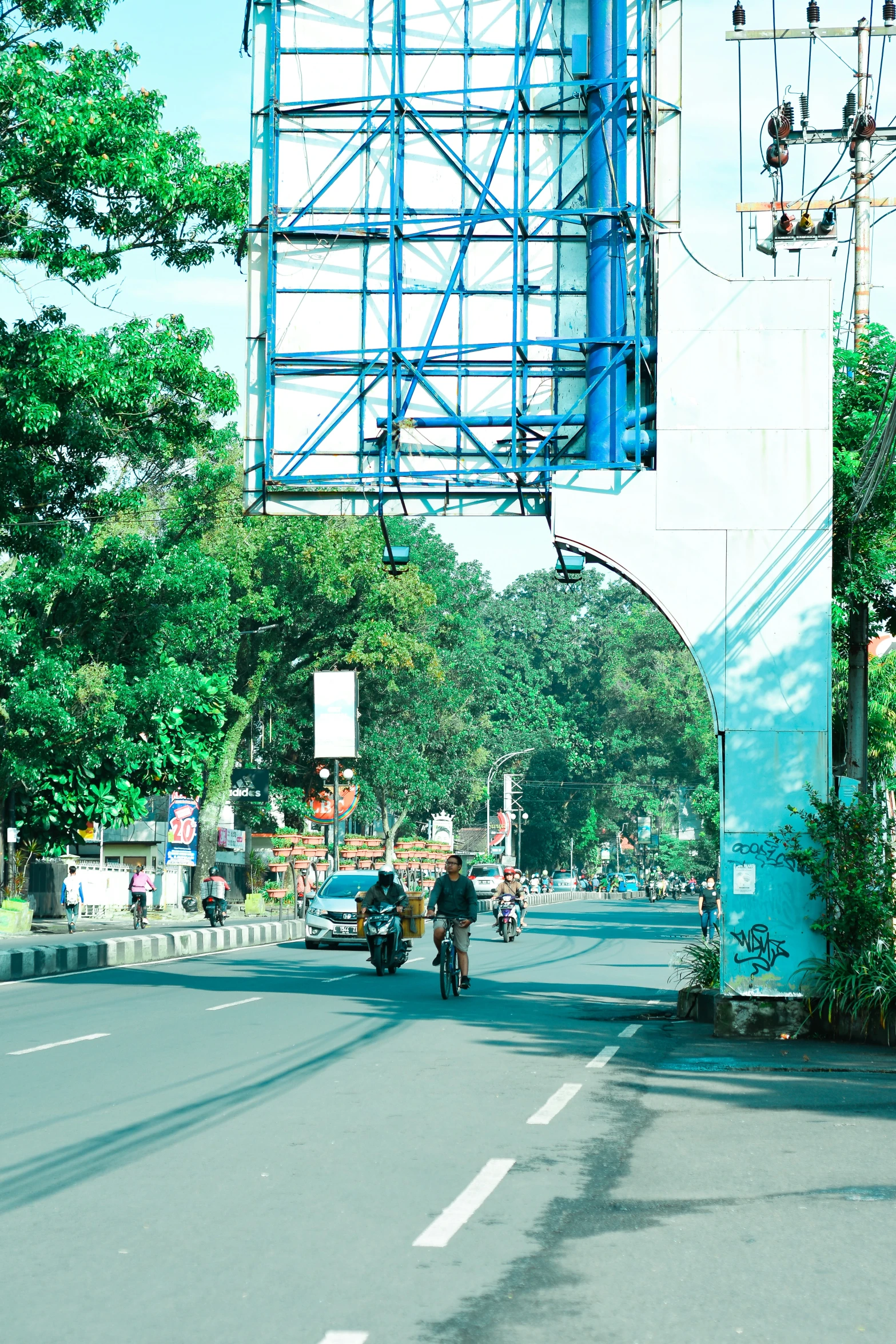 people are riding down a street under a traffic sign