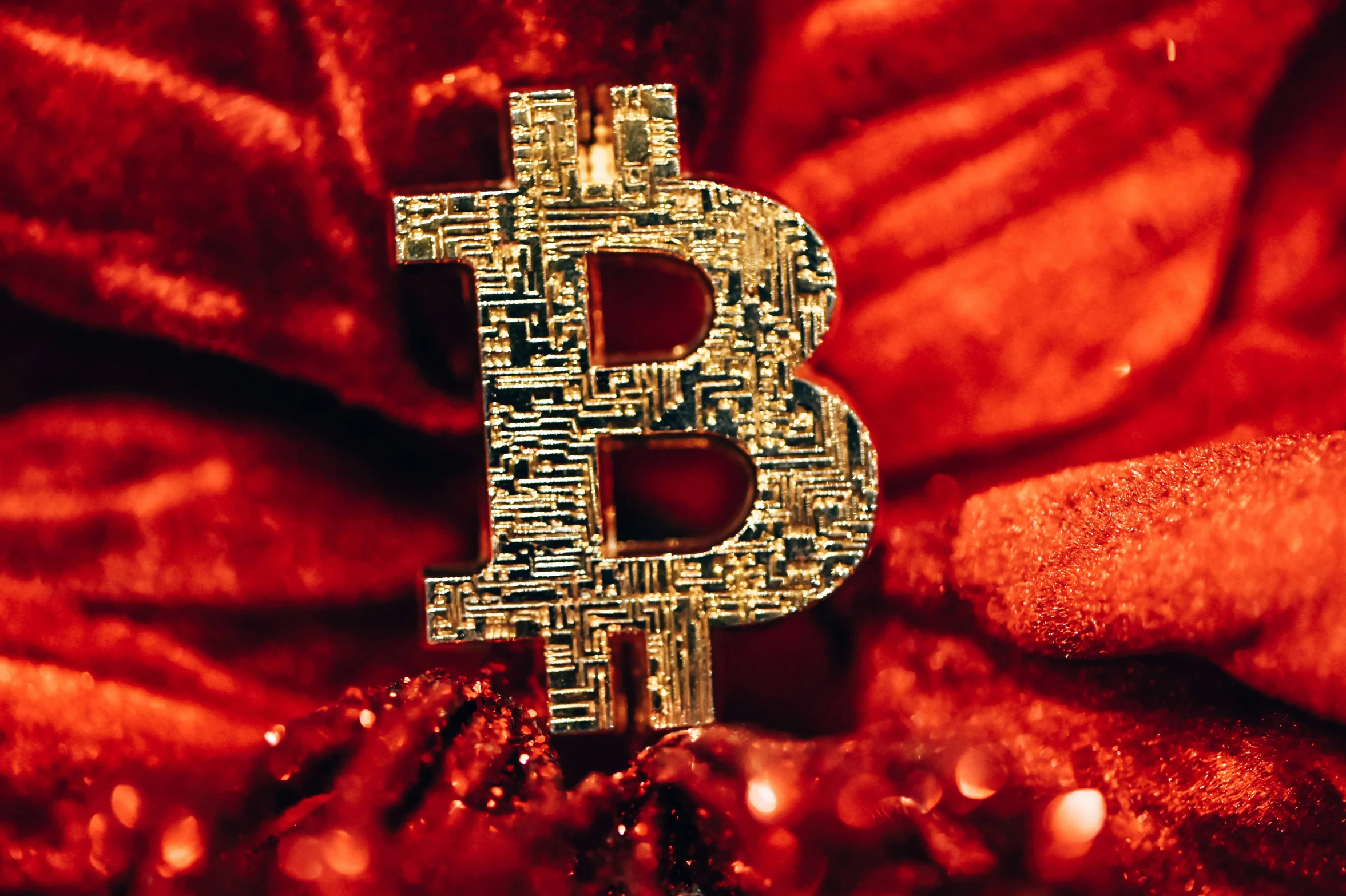 a golden bit coin is standing on a red background