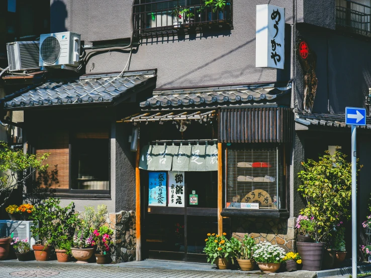 an old chinese shop with lots of flowers outside