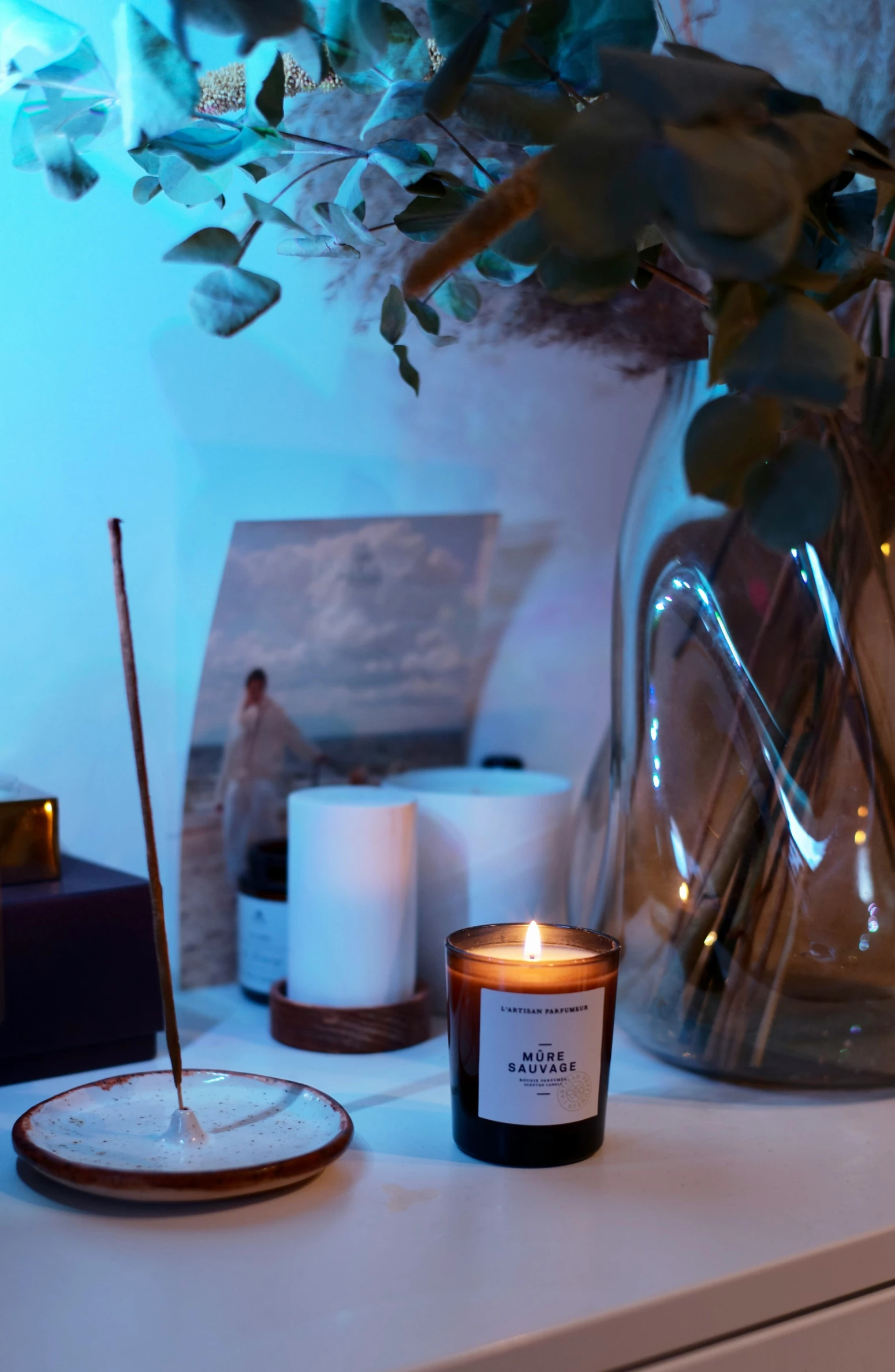 an arrangement of candles, pictures, and other items are placed on the table