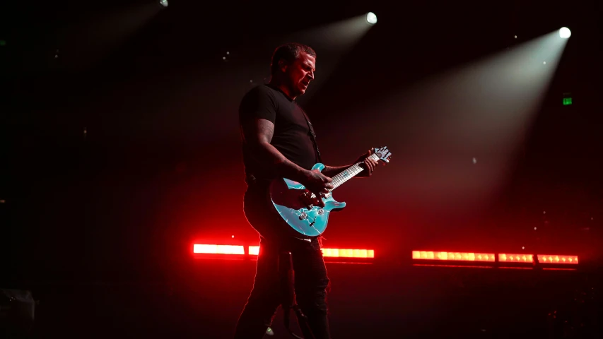 the guitarist is standing on stage at the concert