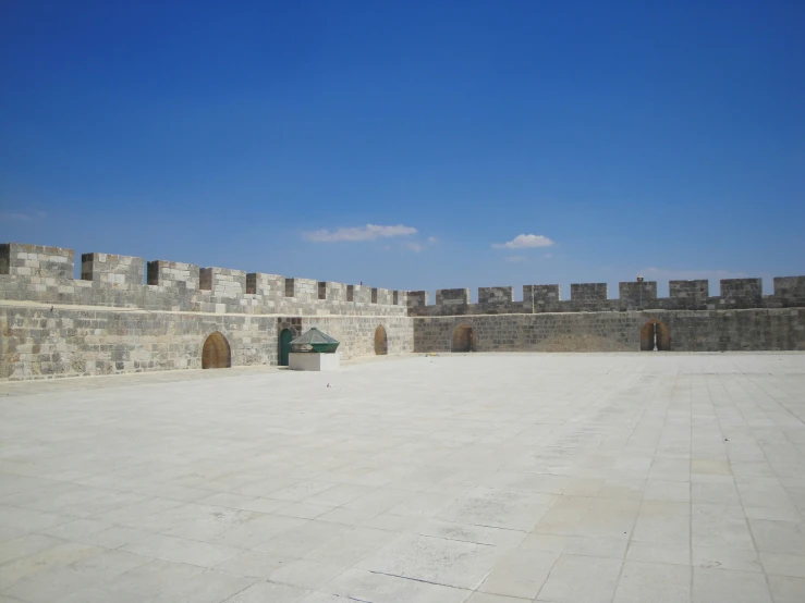 an empty courtyard is shown in front of an old brick wall