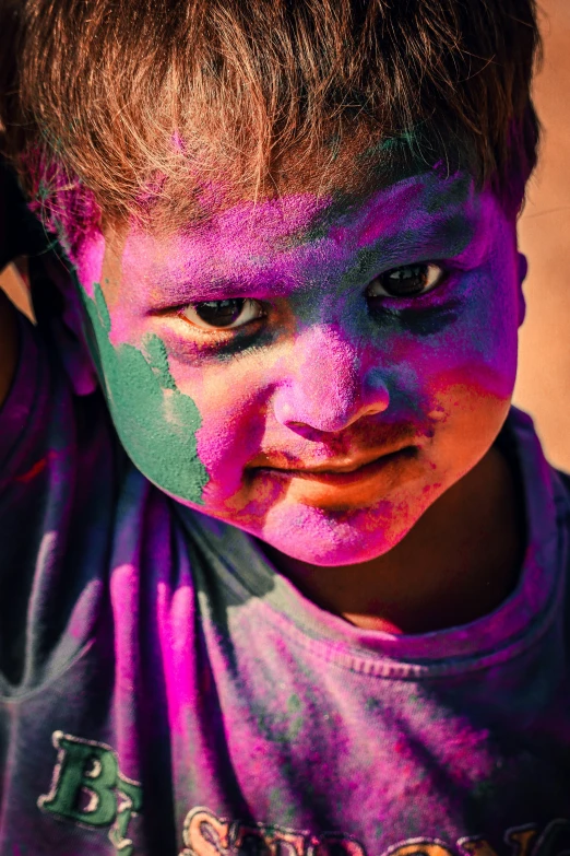 a young child is wearing blue and purple powder