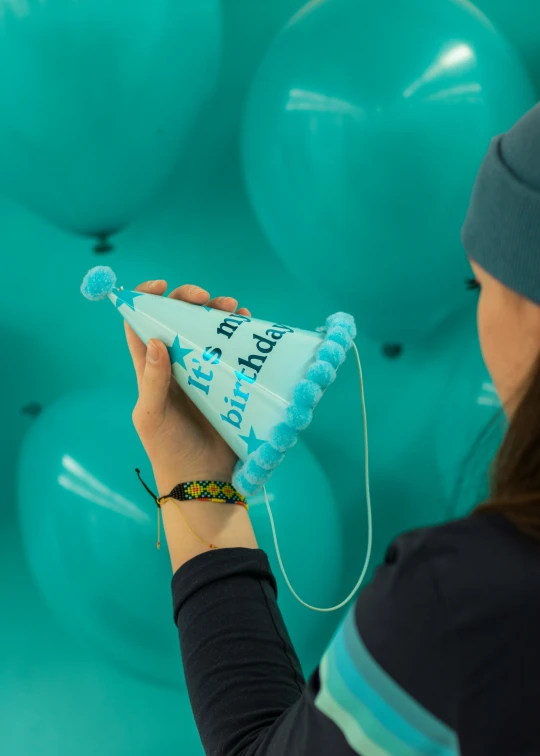 someone using a blue tube to make some birthday cakes