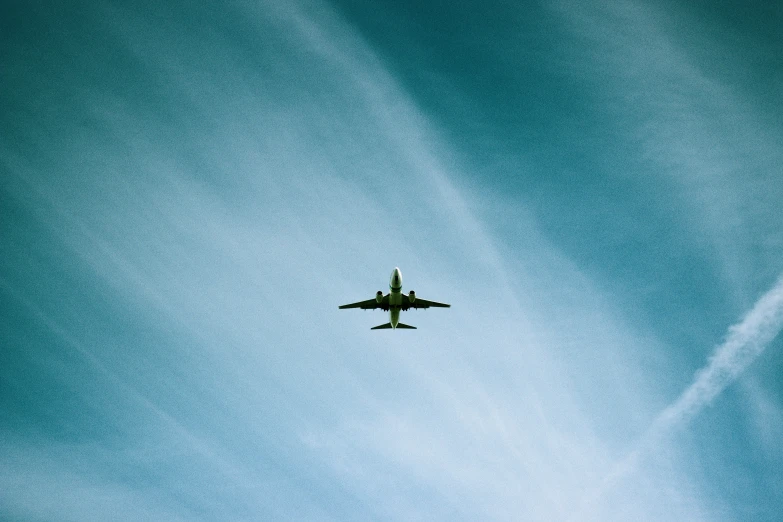 an airplane is flying in the air under a blue sky