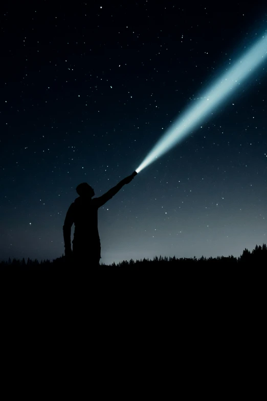 a person standing under a large beam of light