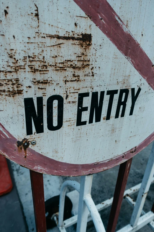 no entry sign on a wooden gate, with rusted metal bars