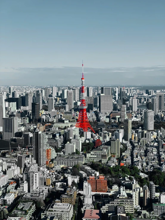 a red tower is in the middle of a big city